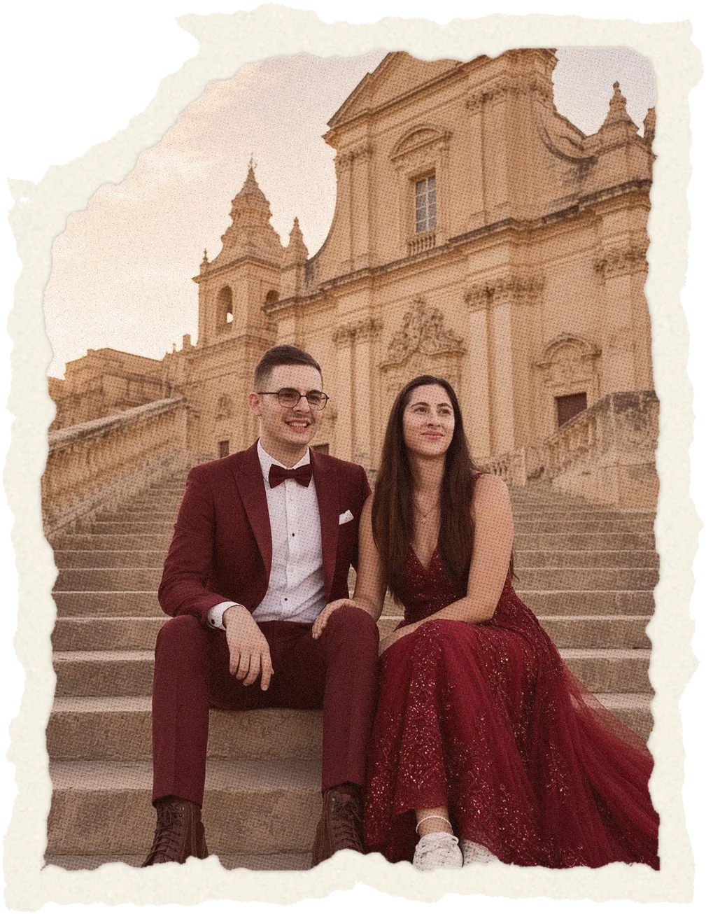Jen and Axel sitting on church steps at sunset